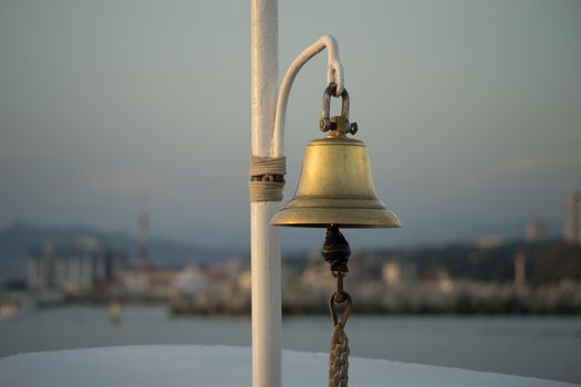 copper bell on the yacht on the background of eroded shoreline