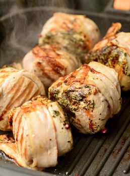 Closeup of pork tenderloin steaks grilling on the pan.