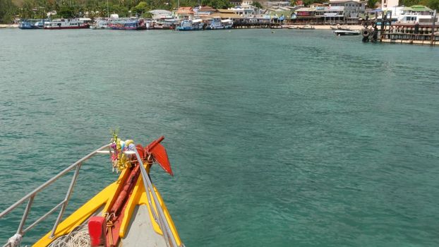 Fishing boat with amulets entering port. Bright boat with thai religious amulets floating towards harbor of diving resort on Ko Tao paradise Island in Thailand