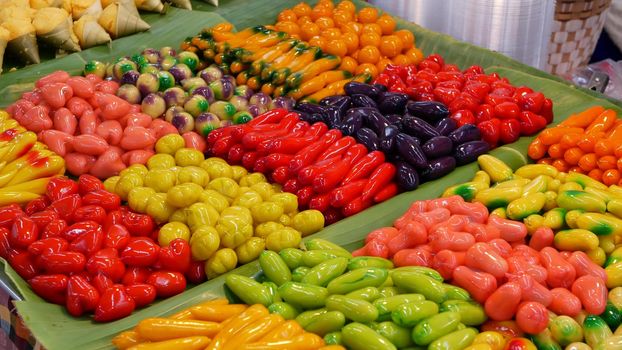 Exotic Oriental Asian sweet delicious desserts, unusual colorful traditional dishes on the counters of a bazar with street food. Evening food court in bangkok, the capital of cooking. Night market