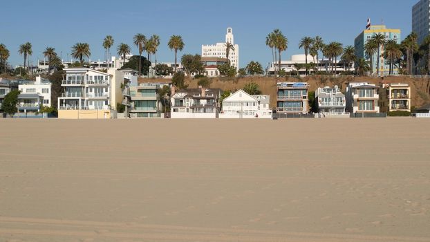 California summertime beach aesthetic, sunny blue sky, sand and many different beachfront weekend houses. Seafront buildings, real estate in Santa Monica pacific ocean resort near Los Angeles CA USA.