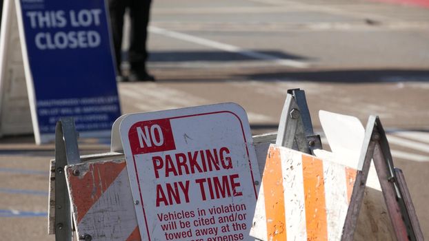Parking lot sign as symbol of traffic difficulties and transportation issues in busy urban areas of USA. Public paid parking zone in downtown of San Diego, California. Limited space for cars in city.