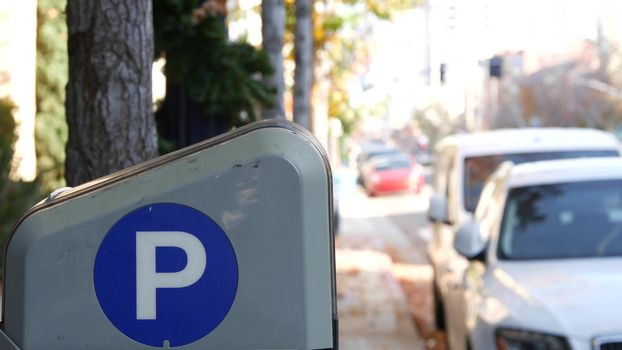 Parking lot sign as symbol of traffic difficulties and transportation issues in busy urban areas of USA. Public paid parking zone in downtown of San Diego, California. Limited space for cars in city.