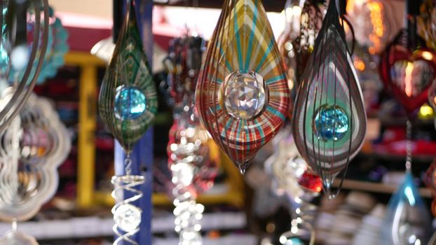 Colorful geometric metallic wind spinner, garden hypnotic surreal decoration, California USA. 3D kinetic rotating iridescent magnetic multi colored air spiral. Shimmering mesmerising optical illusion.