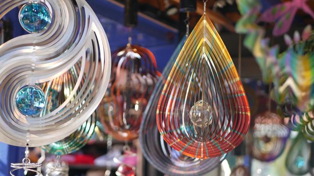 Colorful geometric metallic wind spinner, garden hypnotic surreal decoration, California USA. 3D kinetic rotating iridescent magnetic multi colored air spiral. Shimmering mesmerising optical illusion.