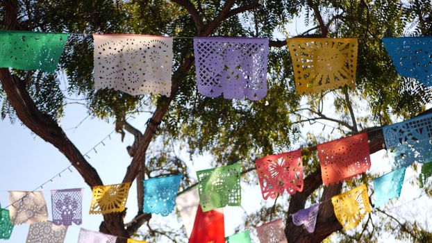 Colorful mexican perforated papel picado banner, festival colourful paper garland. Multi colored hispanic folk carved tissue flags, holiday or carnival. Authentic fiesta decoration in Latin America.
