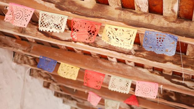 Colorful mexican perforated papel picado banner, festival colourful paper garland. Multi colored hispanic folk carved tissue flags, holiday or carnival. Authentic fiesta decoration in Latin America.