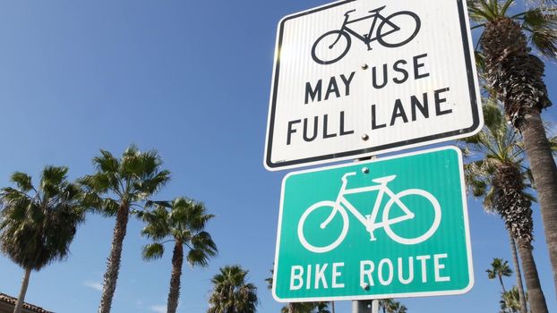 Bike Route green road sign in California, USA. Bicycle lane singpost. Bikeway in Oceanside pacific tourist resort. Cycleway signboard and palm. Healthy lifestyle, recreation and safety cycling symbol.