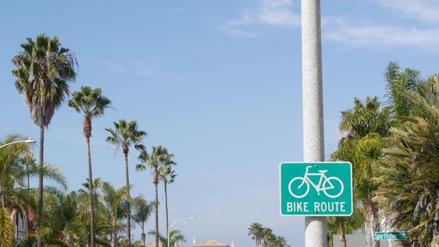 Bike Route green road sign in California, USA. Bicycle lane singpost. Bikeway in Oceanside pacific tourist resort. Cycleway signboard and palm. Healthy lifestyle, recreation and safety cycling symbol.