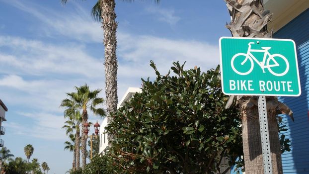 Bike Route green road sign in California, USA. Bicycle lane singpost. Bikeway in Oceanside pacific tourist resort. Cycleway signboard and palm. Healthy lifestyle, recreation and safety cycling symbol.