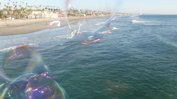 Soap bubbles on pier in California, blurred summertime seamless looped background. Creative romantic metaphor, concept of dreaming, happiness and magic. Abstract symbol of childhood, fantasy, freedom.