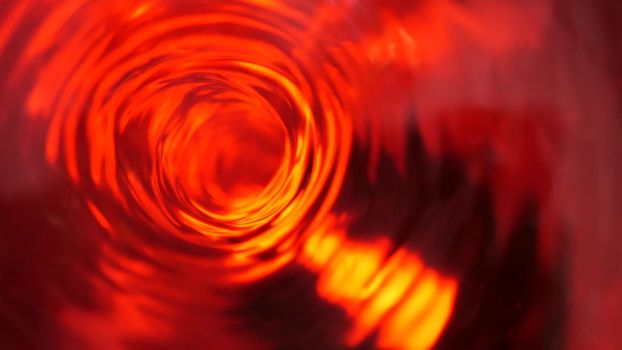 Symbol of hell, inferno and infinity. Red liquid hypnotic looped aqua swirl turning. Meditative luminous whirlpool. Mesmerising spiral tunnel of crystal fluid. Fiery surreal rhythmic water gradient.