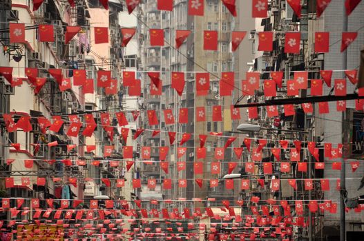 View of rows of strings with waving red flags on street of Singapore. Plenty of red flags on city street