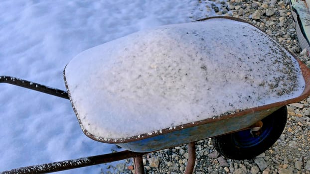 snow on a wheelbarrow in wintertime