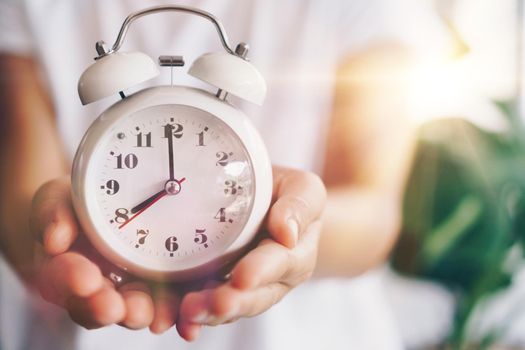 Selective focus of alarm clock with nature bokeh background. lifestyle  productive life concept.