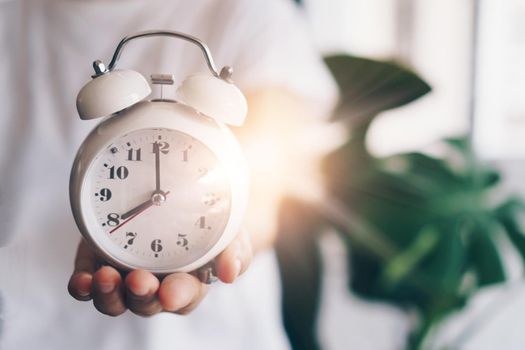 Selective focus of alarm clock with nature bokeh background. lifestyle  productive life concept.