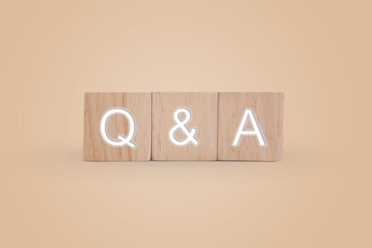 Q and A alphabet on wooden cube in hand hold with background. Question and answer meaning concept.