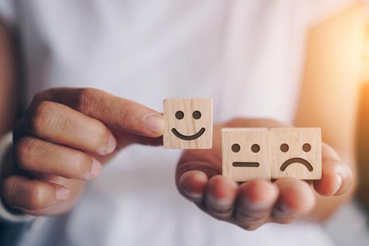 Smile face and cart icon on wood cube. Optimistic person or people feeling inside and service rating when shopping, satisfaction concept in business.