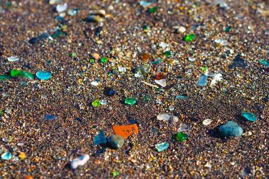 Natural background with sea glass close-up on sand. Vladivostok, Glass beach.