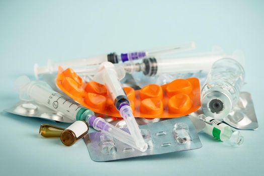 Used syringes and empty medicine containers close-up. Healthcare abstract. The problem of recycling plastic packaging.