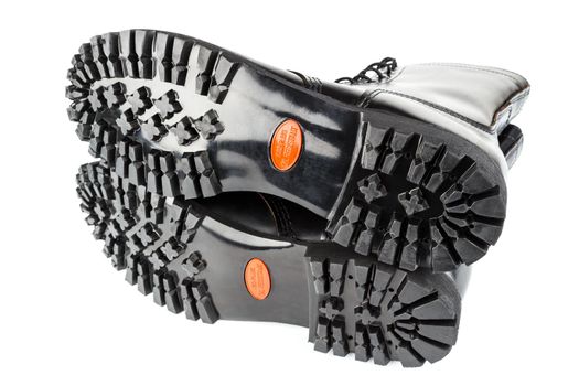 close-up wide angle view of new boots mini lugs black rubber outsole with 120 plus oil resistance grade , isolated on white background