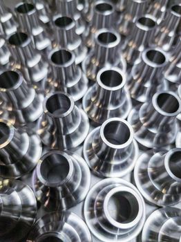 a batch of shiny steel cnc aerospace parts production - close-up with selective focus for industrial background.