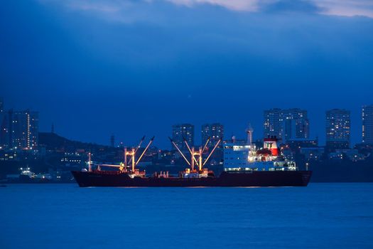 Vladivostok, Russia. Night landscape with the sea and ships on the background of the city.