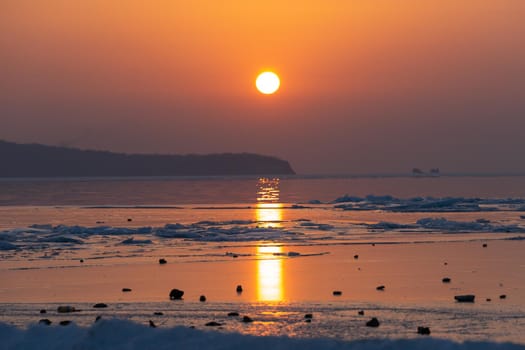 Seascape ice beach and the red sunset.