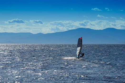 Seascape with sports boat with sail and man