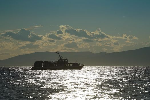 Silhouette of the ship against the seascape in the contra light