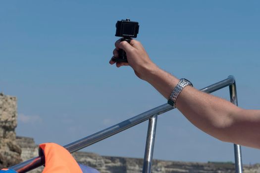 Landscape with male hand view with action camera.