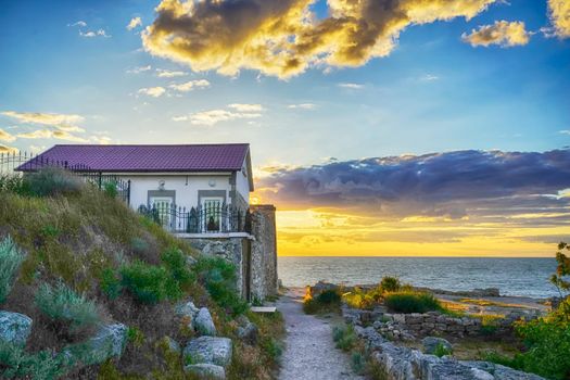 little house by the sea during sunset under the clouds