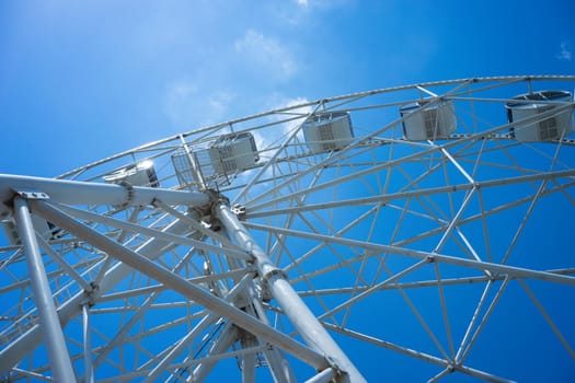 Beautiful and modern Ferris wheel on blue sky background. Evpatoria, Crimea