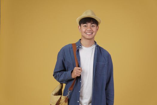 young asian man traveler smiling isolated on yellow background. Travel journey trip in holiday vacation