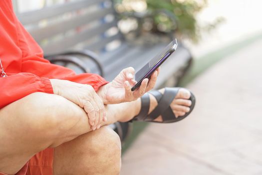asian old elder senior man elderly male using mobile smart phone cellphone outdoor. mature retirement lifestyle