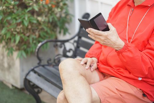 asian old elder senior man elderly male using mobile smart phone cellphone outdoor. mature retirement lifestyle