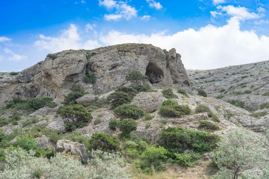 Natural landscape with rocks covered with vegetation against a blue sky. beauty of nature