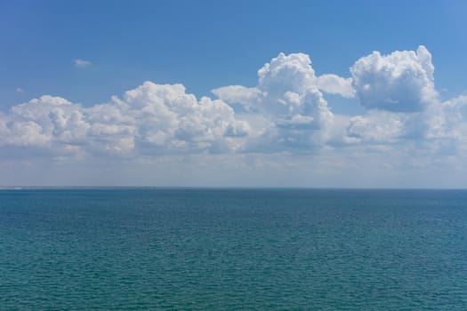 Seascape with water surface and sky with clouds.
