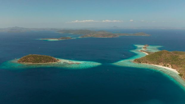 aerial view tropical islands with blue lagoon, coral reef and sandy beach. Palawan, Philippines. Islands of the Malayan archipelago with turquoise lagoons.