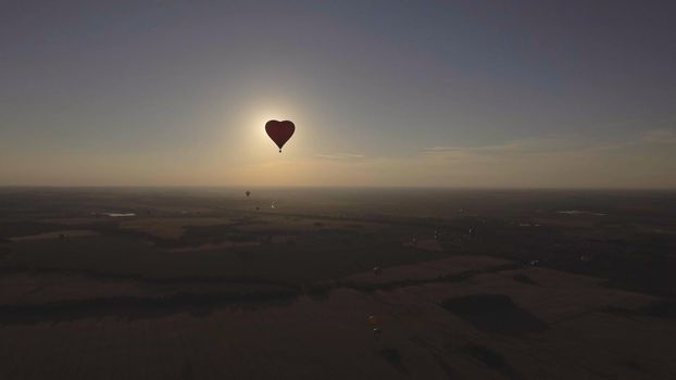 Hot air balloon shape of a heart in the blue sky. Aerostat, Airship. Red balloon.