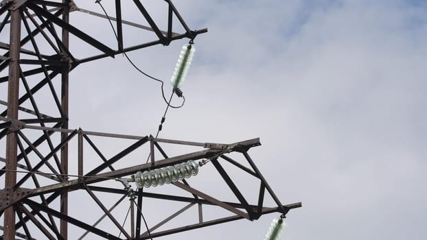 High voltage post.High-voltage tower sky background. High-voltage electrical insulator electric line against the blue sky. Electricity transmission power lines.