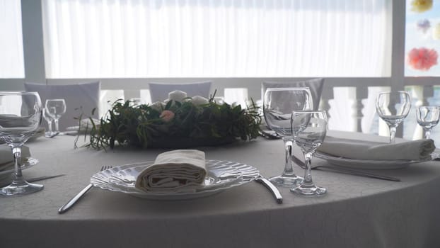 Banquet decorated table, with cutlery. Wedding decor in the banquet hall.Serving of a festive table, plate, napkin, knife, fork. Table setting decoration. Romantic Dinner or other events.