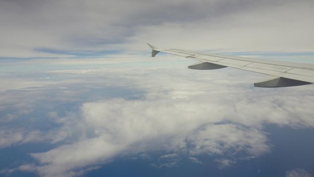 Blue sea or ocean in it and small tropical islands. Looking through window aircraft during flight