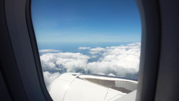 Airplane turbine with propellers in the porthole window. Blue sky view from airplane window.
