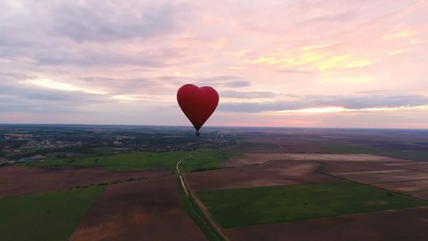 Hot air balloon shape of a heart in the blue sky. Aerostat, Airship. Red balloon.