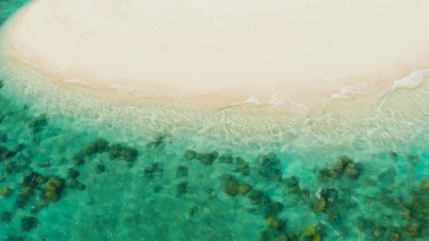 Sandy beach with and azure water of the lagoon,copy space for text, top view. Sea water surface in lagoon. Transparent turquoise ocean water surface. Background texture