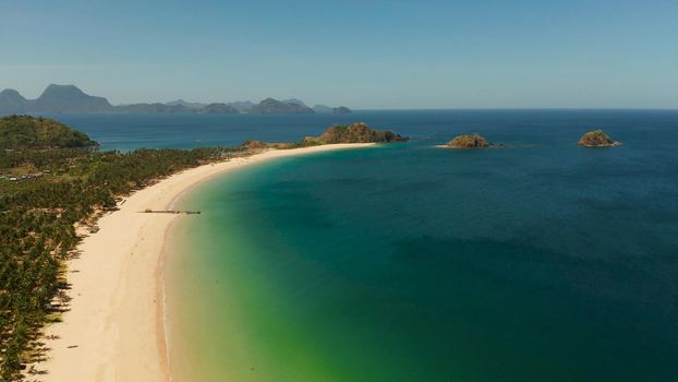 Blue sea and tropical beach, aerial drone. Nacpan, El Nido, Palawan, Philippine Islands. Seascape with tropical beach and islands. Summer and travel vacation concept