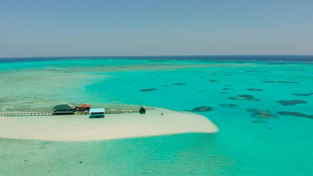 Tropical island with beautiful beach, palm trees and turquoise water view from above. Onok Island, Balabac, Philippines. Summer and travel vacation concept