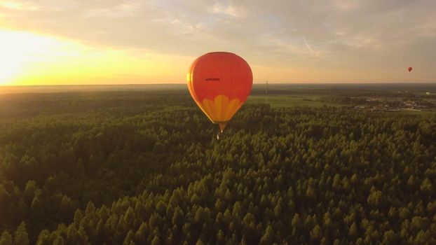 Aerial view Hot air balloon in the sky over a field in the countryside in the beautiful sky and sunset. Balloon silhouette with sunrise, Aerostat fly in the countryside.