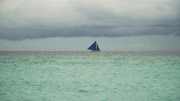 Sailing boat on sea. Sailing ship yachts with blue sails in the ocean. Sailing ship yachts in the sea. Philippines, Boracay. Travel concept.